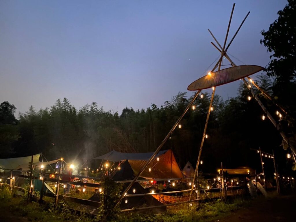 夕暮れ時、明かりがともる桃月園キャンプ場の様子。プライベート感が欲しい人には仕切りのあるキャンプサイトもあります